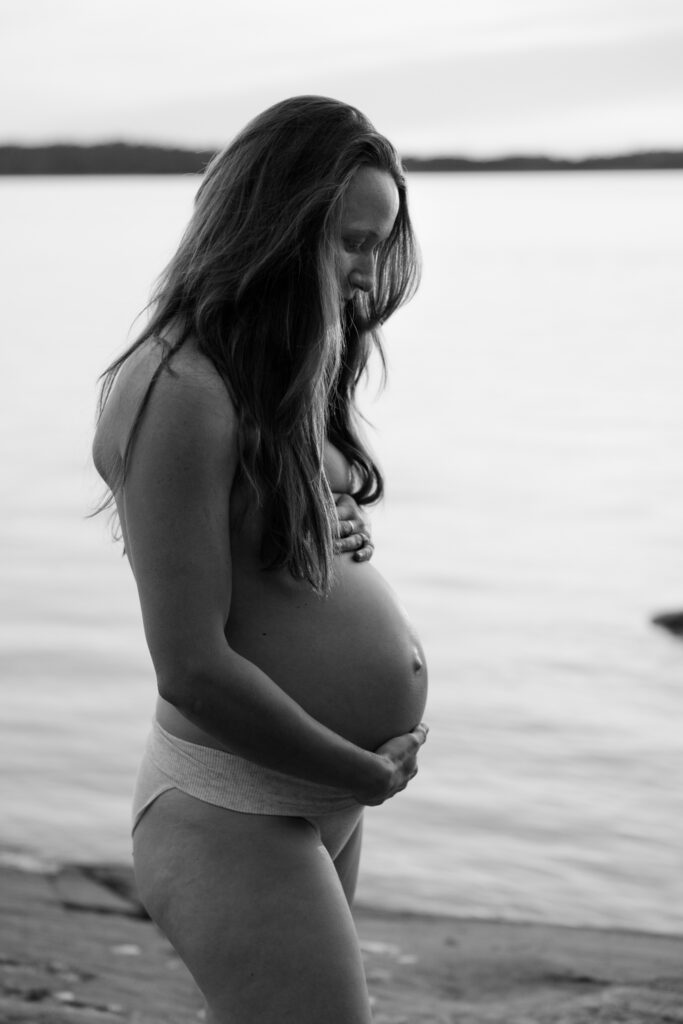 En gravid kvinna vid vattnet.