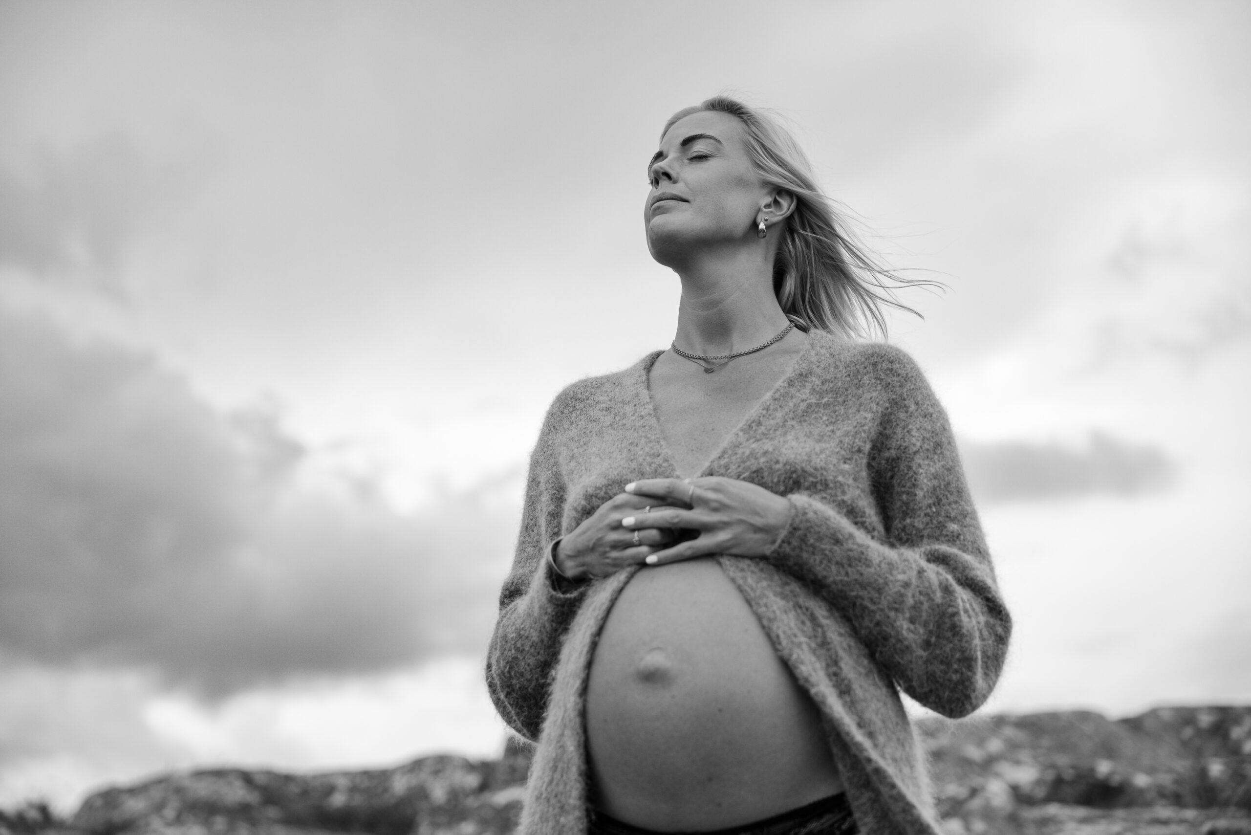 Svartvit bild på gravid kvinna i oväder.