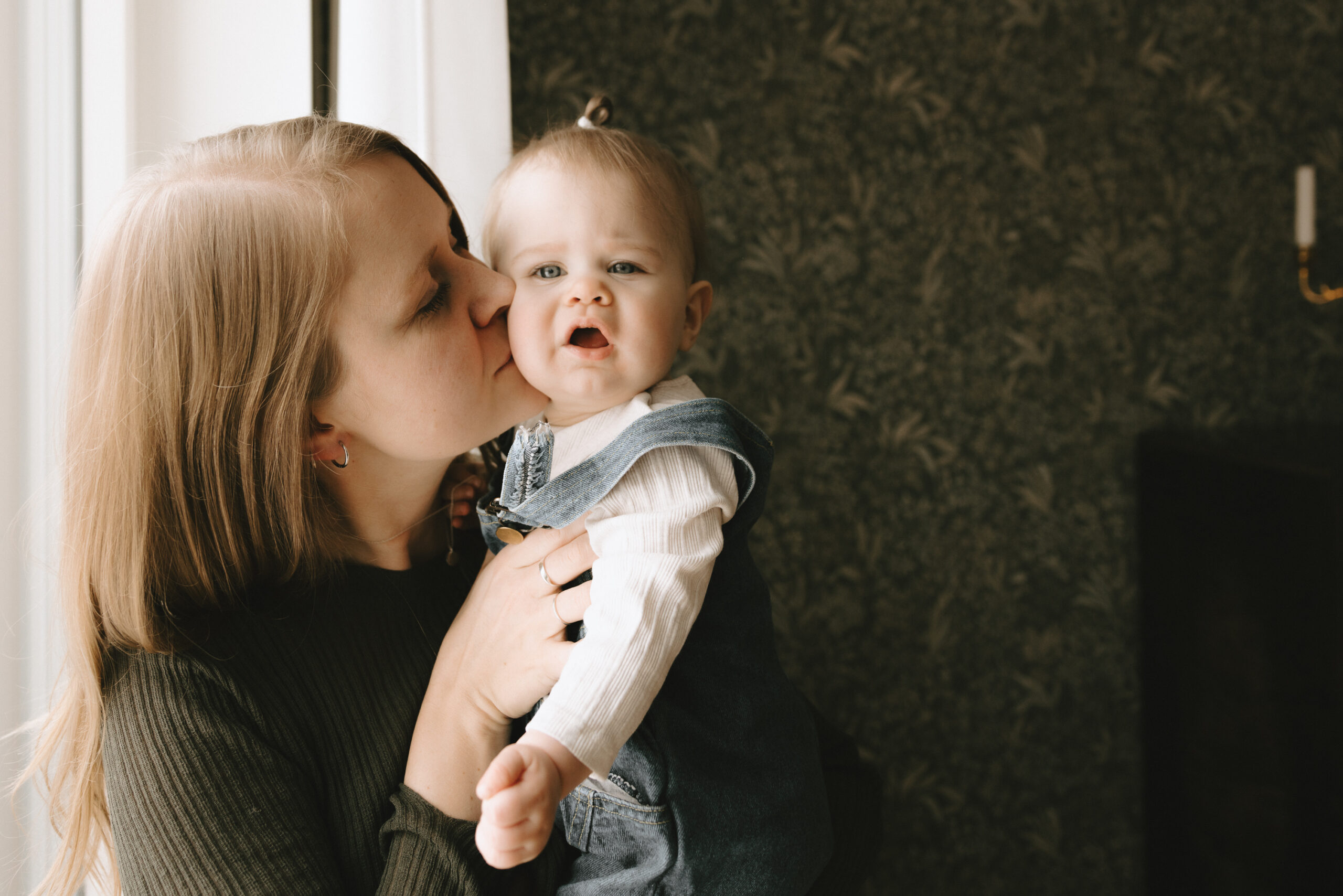En mamma pussar sin dotter på kinden.