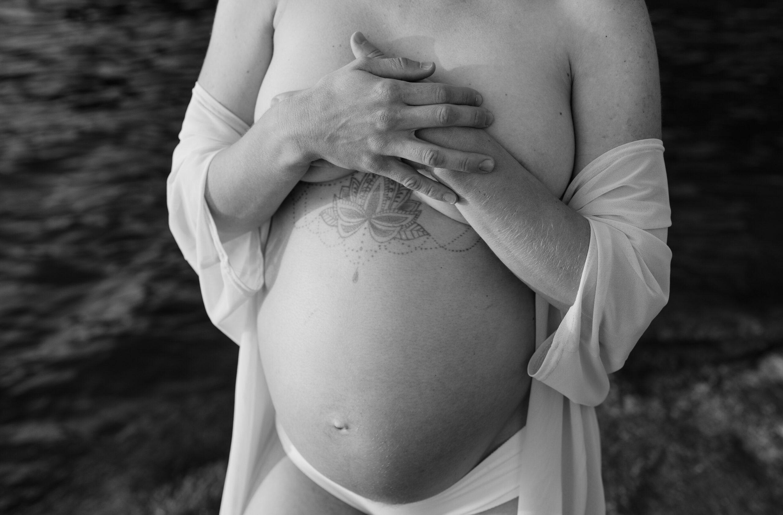 Svartvit närbild på gravidmage.
