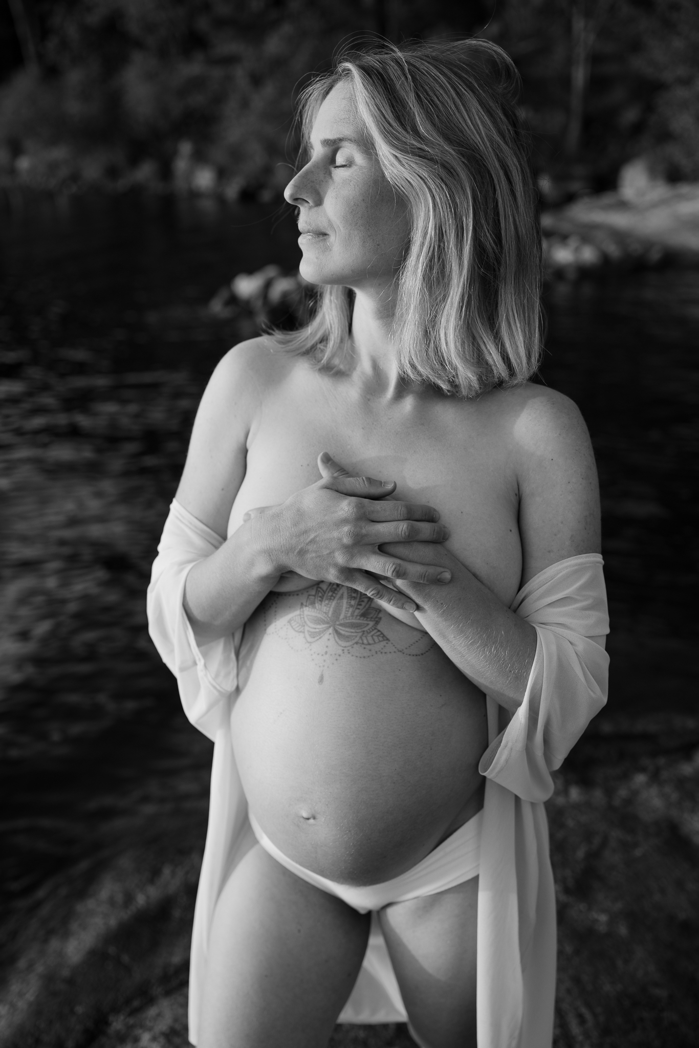 Svartvit bild på gravid kvinna vid havet.